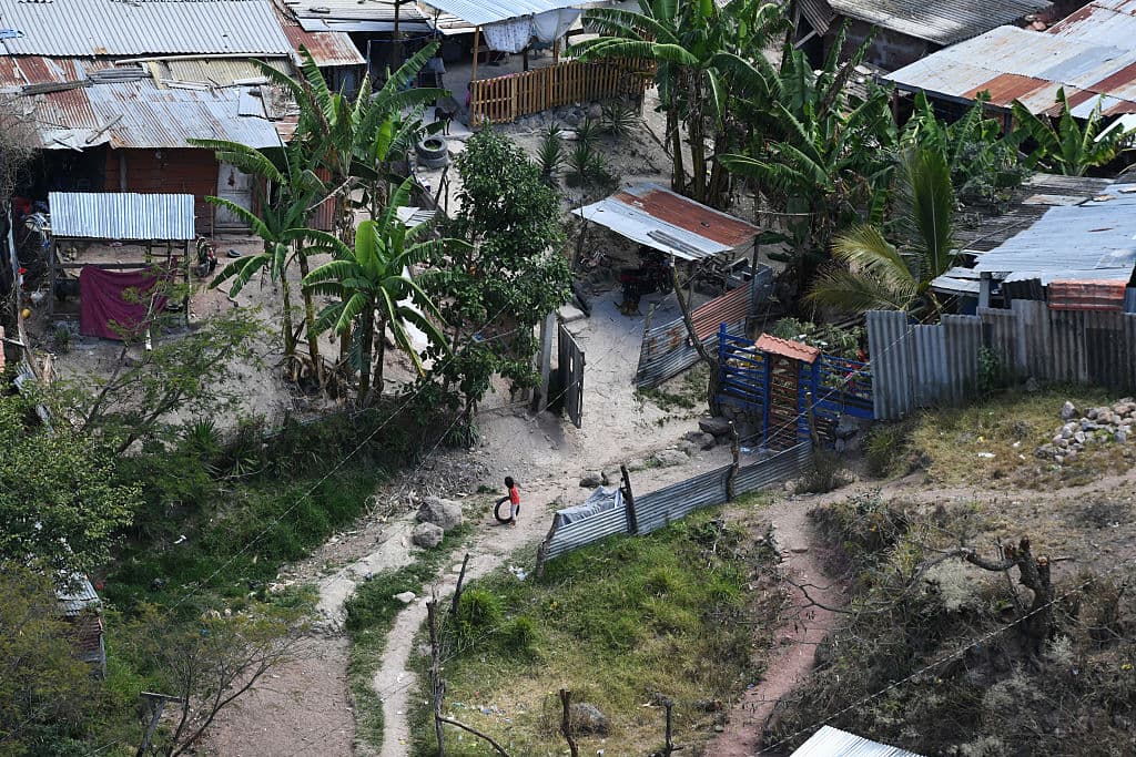 Esta vista aérea muestra a una niña jugando con un neumático en el Sector 2 del barrio Villa Nueva, controlado por las pandillas Barrio 18 y Mara Salvatrucha (MS-13), en el este de Tegucigalpa, el 9 de marzo de 2026. (Orlando SIERRA / AFP vía Getty Images)