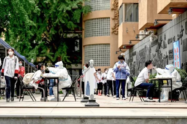 Personal sanitario toma muestras con hisopos a estudiantes para realizarles pruebas de COVID-19 en Beijing, el 7 de junio de 2022. (Jade Gao/AFP vía Getty Images).