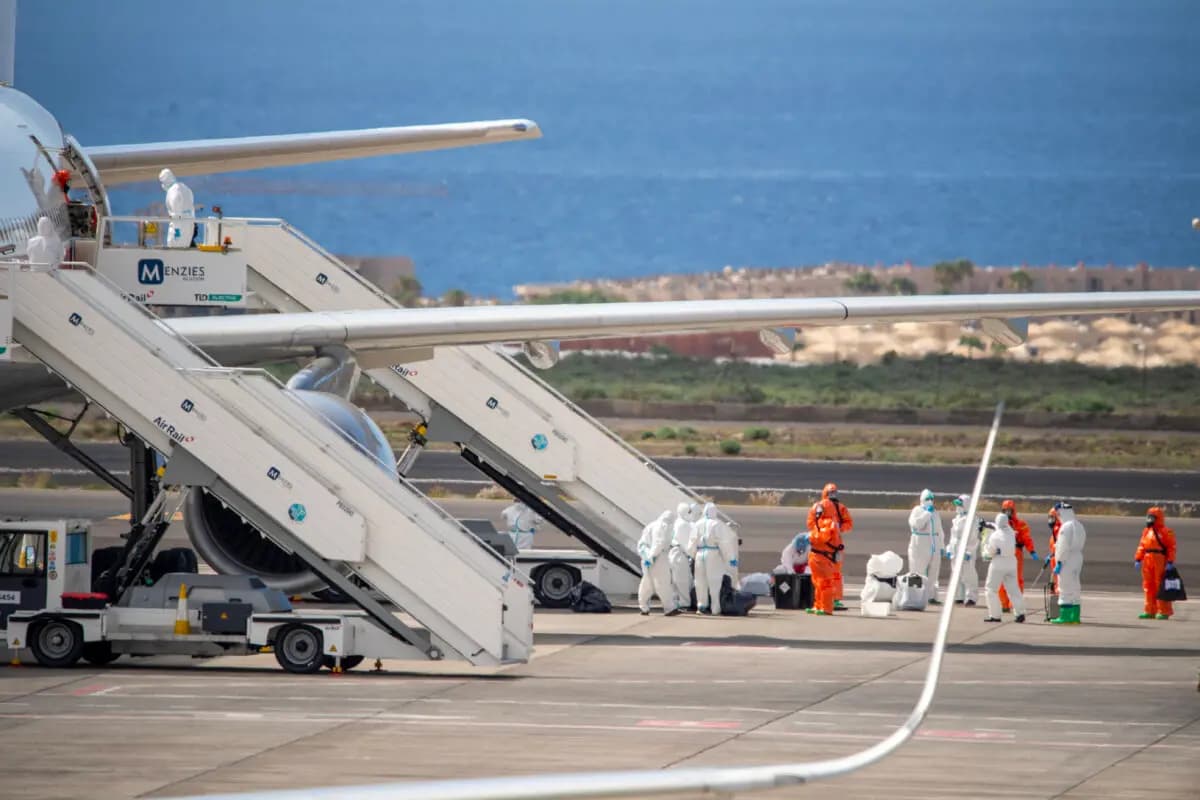 Evacuados españoles vestidos con trajes blancos de protección contra materiales peligrosos abordan un avión Airbus A310 de la fuerza aérea española en el aeropuerto de Tenerife Sur-Reina Sofía después de ser evacuados del crucero MV Hondius, con bandera holandesa y afectado por hantavirus, en la isla de Tenerife, en las Islas Canarias de España, el 10 de mayo de 2026. (Antonio Sempere/AFP vía Getty Images)