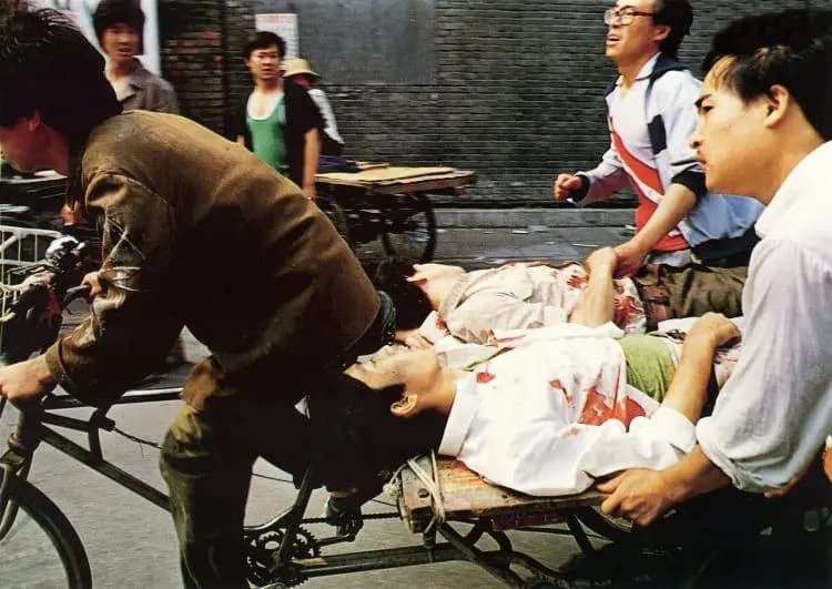 <em>Un conductor traslada en su bicitaxi a estudiantes heridos en la Plaza de Tiananmen en Beijing el 4 de junio de 1989. (64memo.com)</em>
