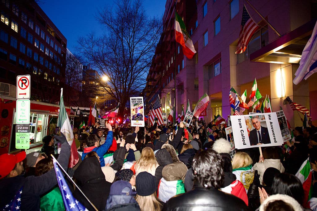 <em>Manifestantes iraníes se congregan durante una protesta organizada por grupos de la diáspora que exigen un cambio político en Irán y responden a los llamamientos de figuras de la oposición, frente a la Sección de Intereses Iraníes en Washington, D.C., el 17 de marzo de 2026. El presidente estadounidense Donald Trump declaró que desconocía si el nuevo líder supremo de Irán, Mojtaba Khamenei, seguía con vida, y añadió que Washington no tenía claro con quién podía negociar en Teherán. (Foto de Amid FARAHI / AFP vía Getty Images)</em>