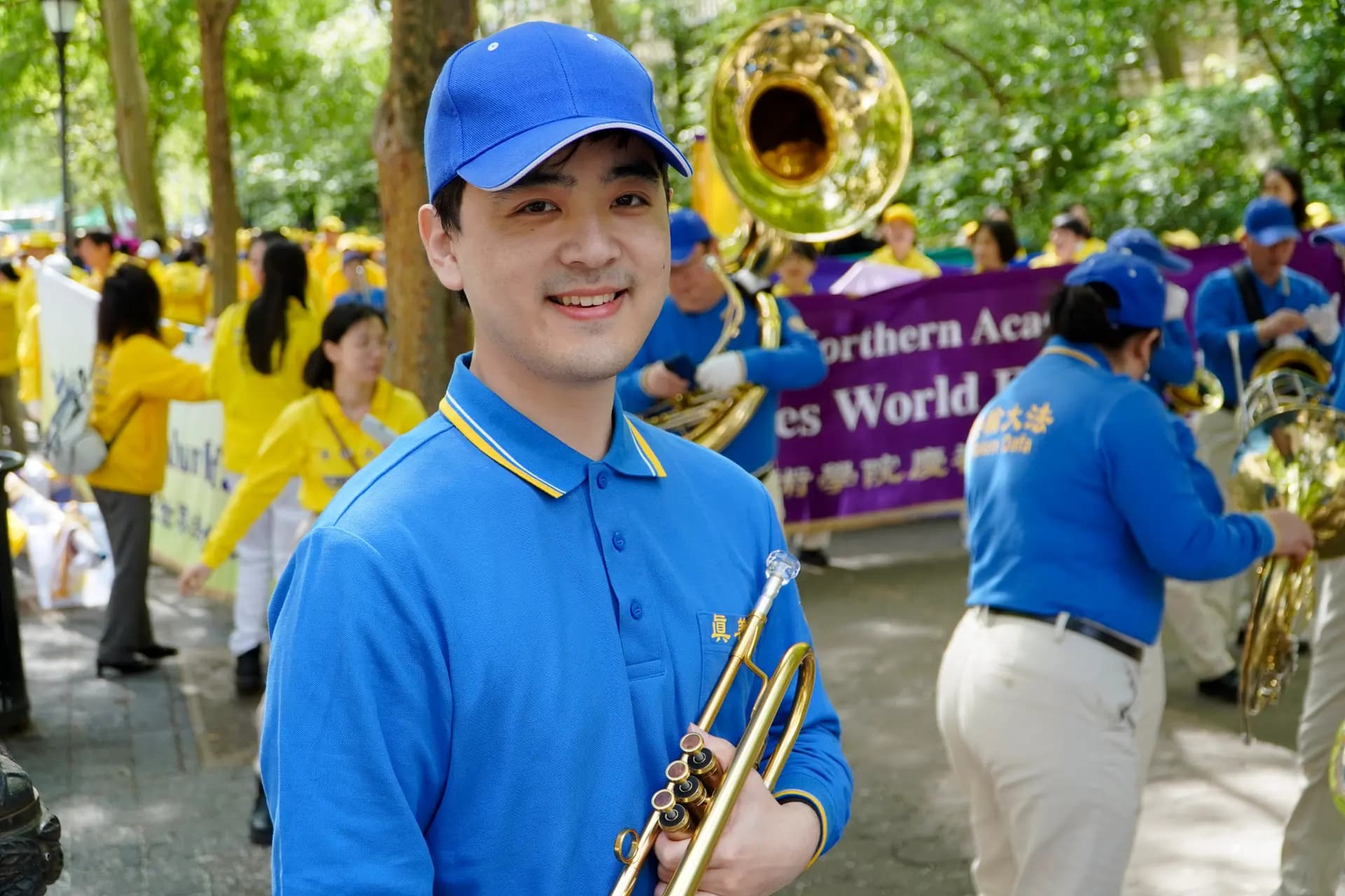 <em>Mark Yang, de 27 años, afirma que su madre practicaba Falun Gong incluso antes de que él naciera. Se encuentra en la plaza Dag Hammarskjöld, donde los practicantes de Falun Gong se preparan para el desfile que celebra el Día Mundial de Falun Dafa, el 13 de mayo de 2026. (Nicholas Zifcak/The Epoch Times).</em>