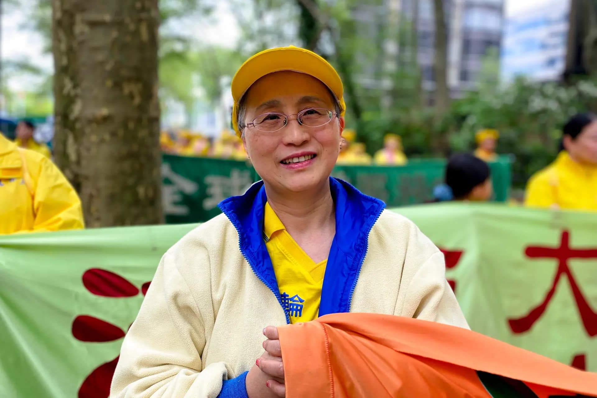 <em>April Zhang, de 56 años, padecía asma desde hacía mucho tiempo antes de comenzar a practicar Falun Gong. Se unió al desfile en Manhattan para celebrar el Día Mundial de Falun Dafa, el 13 de mayo de 2026. (Nicholas Zifcak/The Epoch Times).</em>