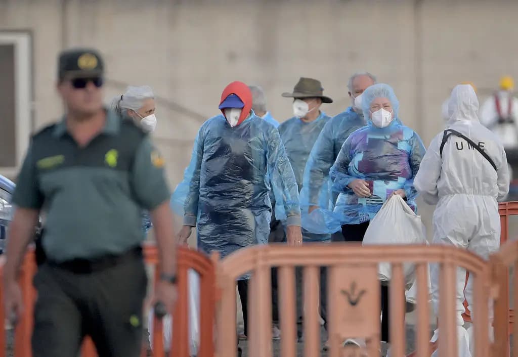 <em>Pasajeros del crucero MV Hondius, afectado por el hantavirus, esperan para abordar los autobuses tras desembarcar en el puerto de Granadilla de Abona, en la isla de Tenerife (Islas Canarias, España), el 11 de mayo de 2026. (Jorge Guerrero/AFP vía Getty Images).</em>