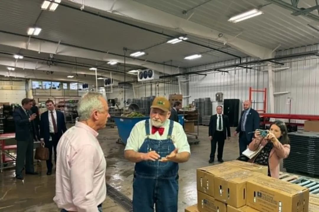 El granjero Lee Jones, copropietario de The Chef's Garden en Huron, Ohio, le cuenta la historia de la granja al secretario del HHS, Robert F. Kennedy Jr., el 6 de mayo de 2026. (Jeff Louderback/The Epoch Times)