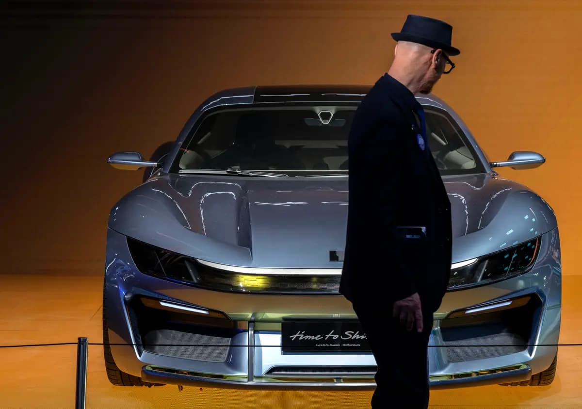 Un asistente pasa junto a un deportivo eléctrico recién presentado por el fabricante chino Lynk & Co, una división de Geely, durante la jornada dedicada a los medios de comunicación en el Salón Internacional del Automóvil de Beijing, celebrado en Beijing el 24 de abril de 2026. (Kevin Frayer/Getty Images)