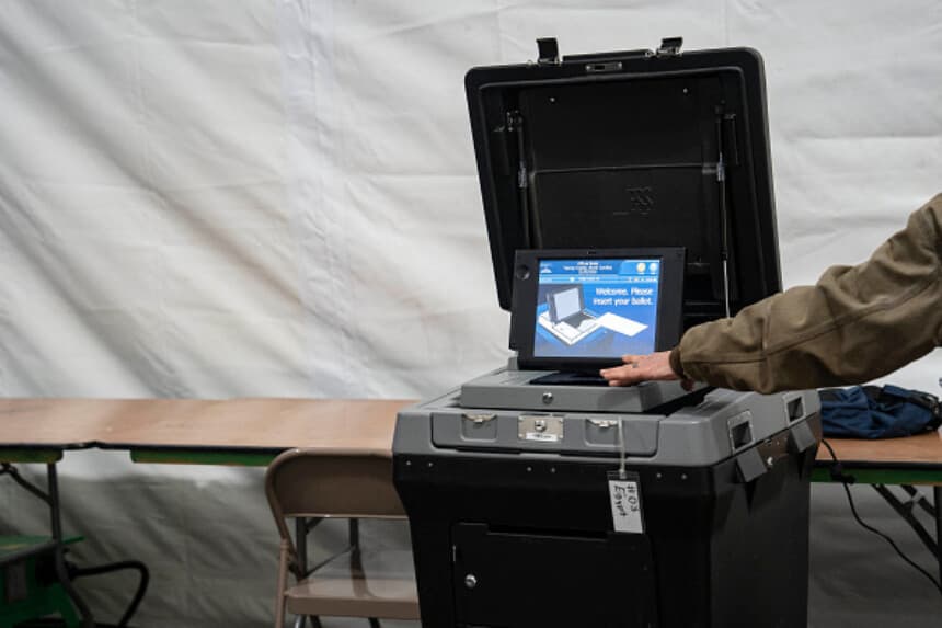 Foto Ilustrativa: Un funcionario electoral toca una máquina de votación dentro de una carpa el día de las elecciones, el 5 de noviembre de 2024 en Burnsville, Carolina del Norte. (Foto de Allison Joyce / AFP) (ALLISON JOYCE/AFP vía Getty Images).