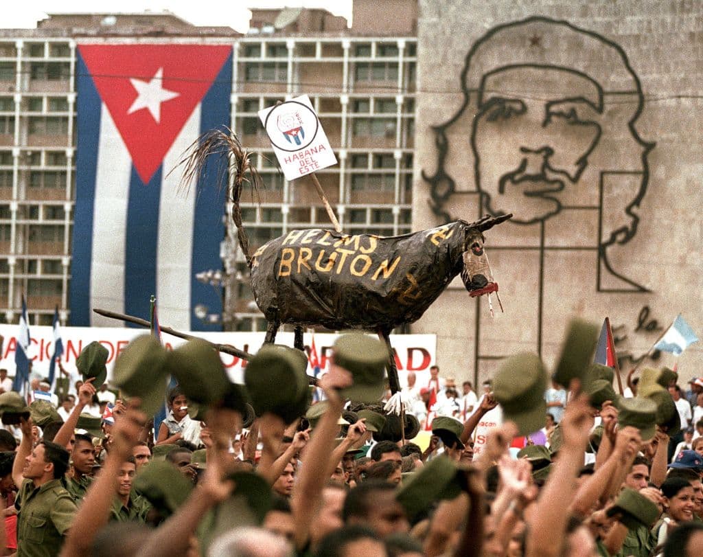 <em>Durante la marcha por el Dia del Trabajador celebrada en La Habana el 01 de mayo de 1999, militares cubanos cargan un muneco representando un asno con las inscripciones de Helms-Bruton alusivo a los nombres de los senadores norteamericanos Helms-Burton. (NIURKA BARROSO/AFP via Getty Images)</em>