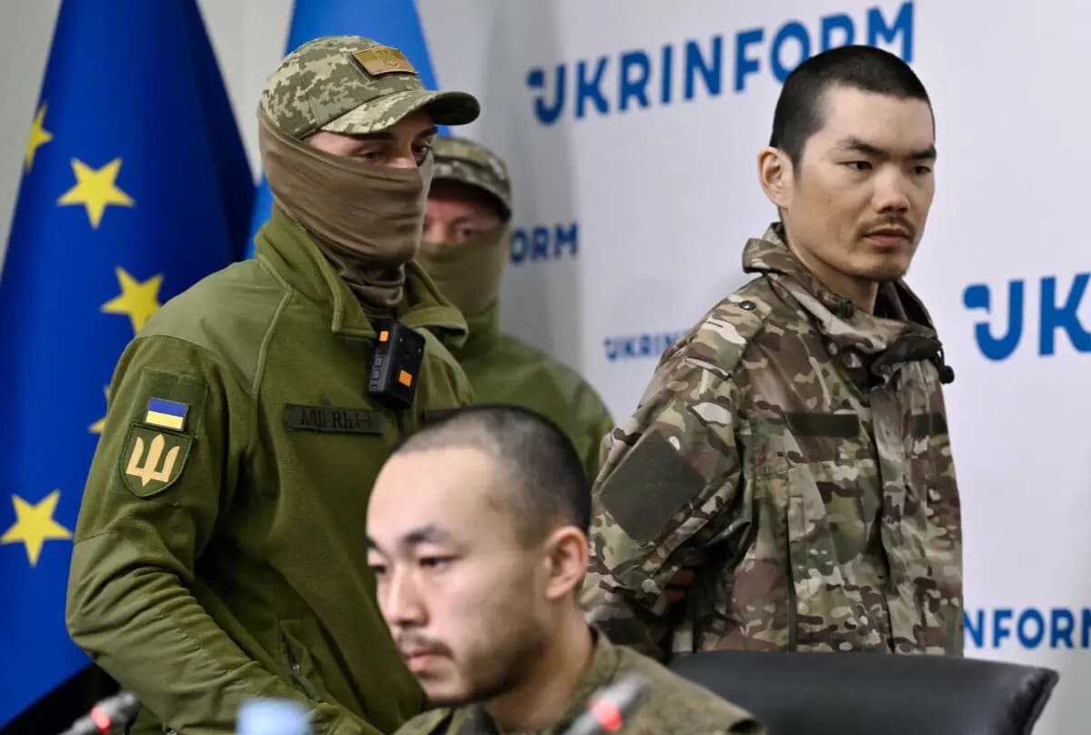 Los ciudadanos chinos Wang Guangjung (D) y Zhang Renbo (C) asisten a una rueda de prensa en Kiev tras ser capturados por las fuerzas ucranianas en la región de Donetsk mientras luchaban por Rusia durante lo que, según afirmaron, era su primera misión de combate en el frente, el 14 de abril de 2025. (Genya Savilov/AFP vía Getty Images)