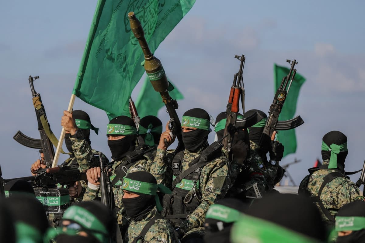 Los terroristas de Hamás aseguran un área antes de entregar a un rehén israelí-estadounidense a un equipo de la Cruz Roja en la ciudad de Gaza el 1 de febrero de 2025. Fotografía de SAEED JARAS/Middle (East Images/AFP vía Getty Images)