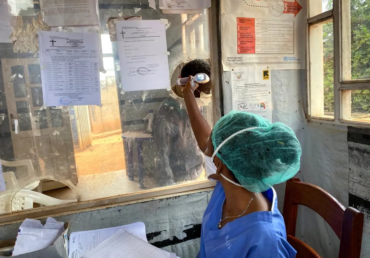 Un profesional sanitario toma la temperatura a una persona en el Hospital Matanda de Butembo, donde falleció la primera víctima del ébola durante un brote anterior del virus en la provincia de Kivu del Norte, Congo, el 11 de febrero de 2021. (Al-hadji Kudra Maliro/AP Photo).