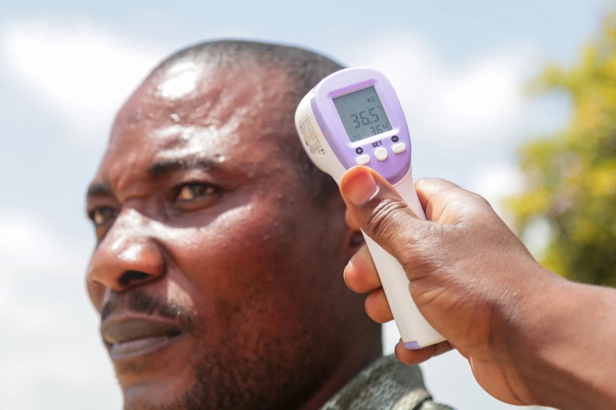 Un funcionario de sanidad fronteriza toma la temperatura de un pasajero en el aeropuerto de Bunia, Congo, el 21 de mayo de 2026. (Seros Muyisa/AFP vía Getty Images).