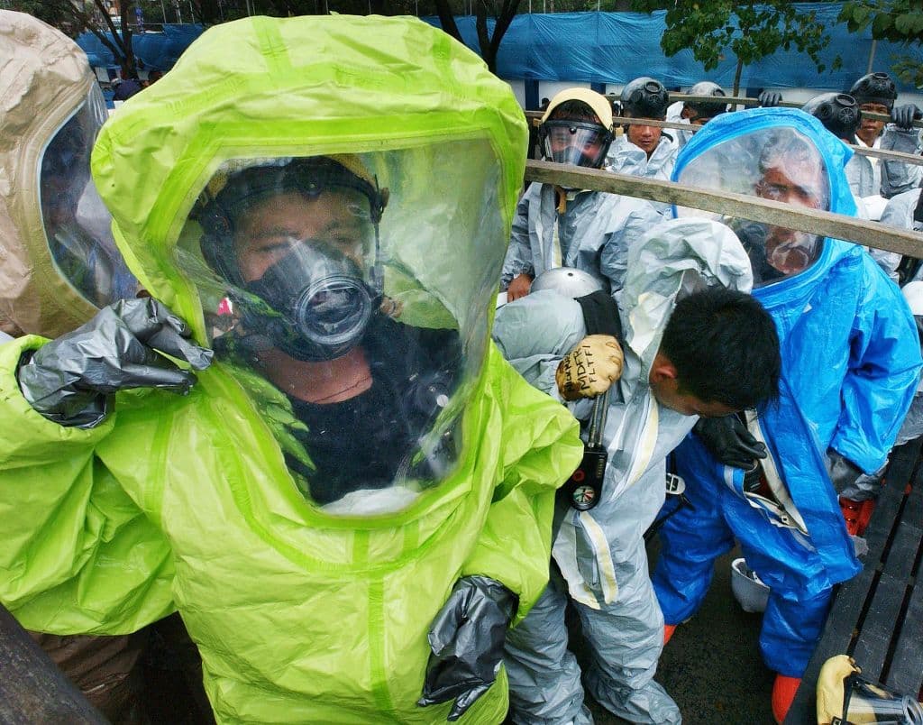 <em>Policías visten sus nuevos trajes de protección química y biológica como parte de su arsenal moderno contra posibles amenazas terroristas de guerra química y biológica durante las ceremonias del 12.º aniversario de la Policía Nacional de Filipinas en el campamento suburbano de Crame, el 30 de enero de 2003. (Foto de ROMEO GACAD/AFP vía Getty Images)</em>