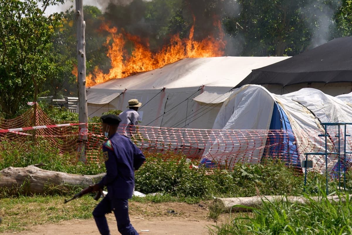 Un guardia de seguridad corre frente a un centro de tratamiento del ébola en llamas en Rwampara, Congo, el 21 de mayo de 2026. (Foto de Dirole Lotsima Dieudonne/AP).