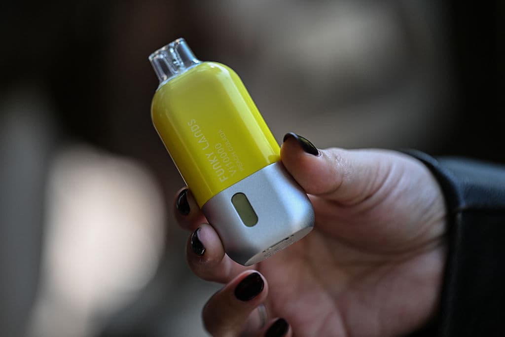 Una joven sostiene un cigarrillo electrónico en el barrio de La Condesa, Ciudad de México, el 11 de diciembre de 2025. El Congreso mexicano aprobó definitivamente el 10 de diciembre un proyecto de ley que impone penas de hasta ocho años de prisión por la venta de cigarrillos electrónicos y productos similares. (Foto de Yuri CORTEZ / AFP vía Getty Images)