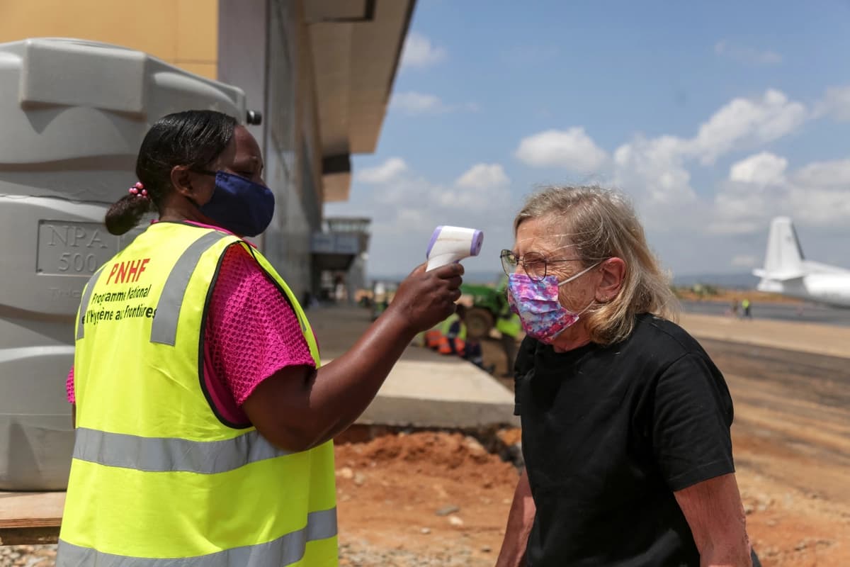Un funcionario de salud fronterizo toma la temperatura a un pasajero en el aeropuerto de Bunia, en la República Democrática del Congo, el 21 de mayo de 2026. (Seros Muyisa/AFP)