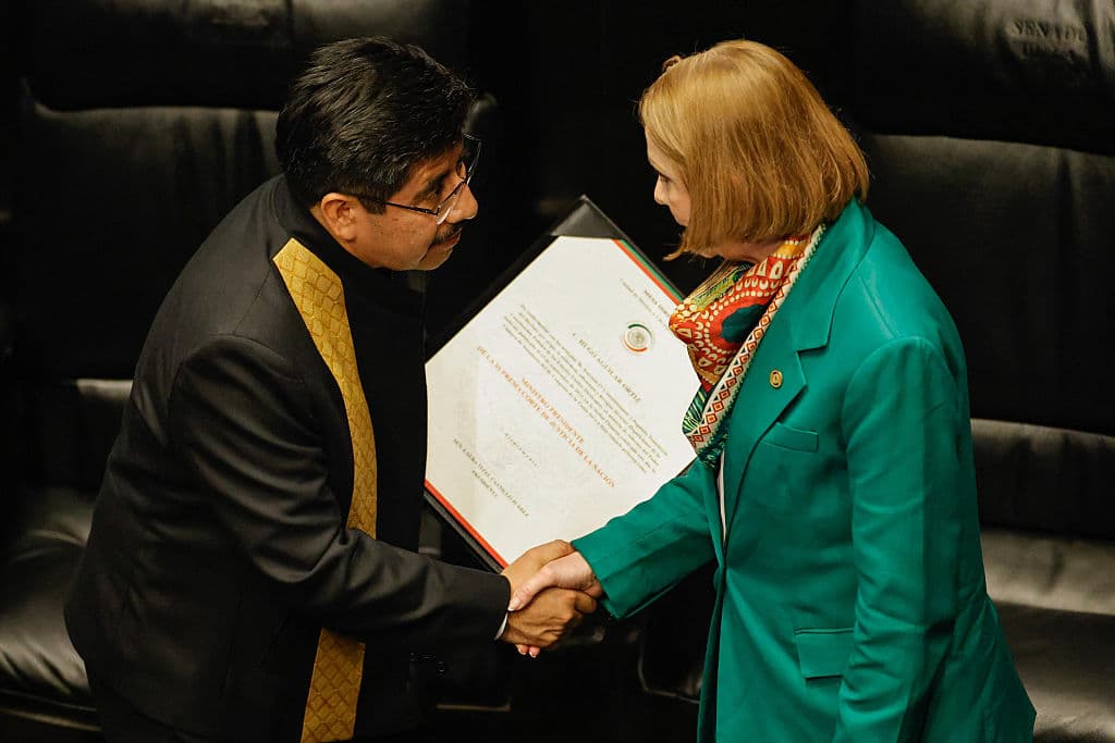 <em>El nuevo presidente de la Suprema Corte de Justicia de México, Hugo Aguilar Ortiz (izq.), estrecha la mano de la senadora Laura Itzel Castillo (der.) durante la ceremonia de investidura de los primeros magistrados elegidos por voto popular en el Senado de la República en la Ciudad de México, el 1 de septiembre de 2025. Hugo Aguilar Ortiz, defensor de los derechos indígenas y exasesor del movimiento guerrillero zapatista, es el primer presidente de la Suprema Corte de Justicia de México elegido por voto popular. (Foto de Rodrigo Oropeza/AFP vía Getty Images)</em>