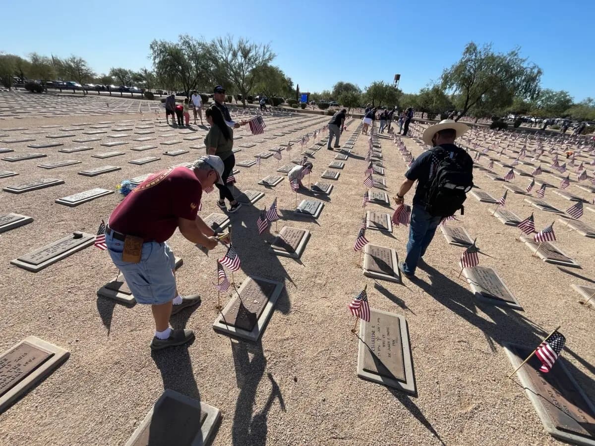 <em>Voluntarios colocan banderas en el Cementerio Nacional Conmemorativo de Arizona en Phoenix el 23 de mayo de 2026. (Allan Stein/The Epoch Times).</em>