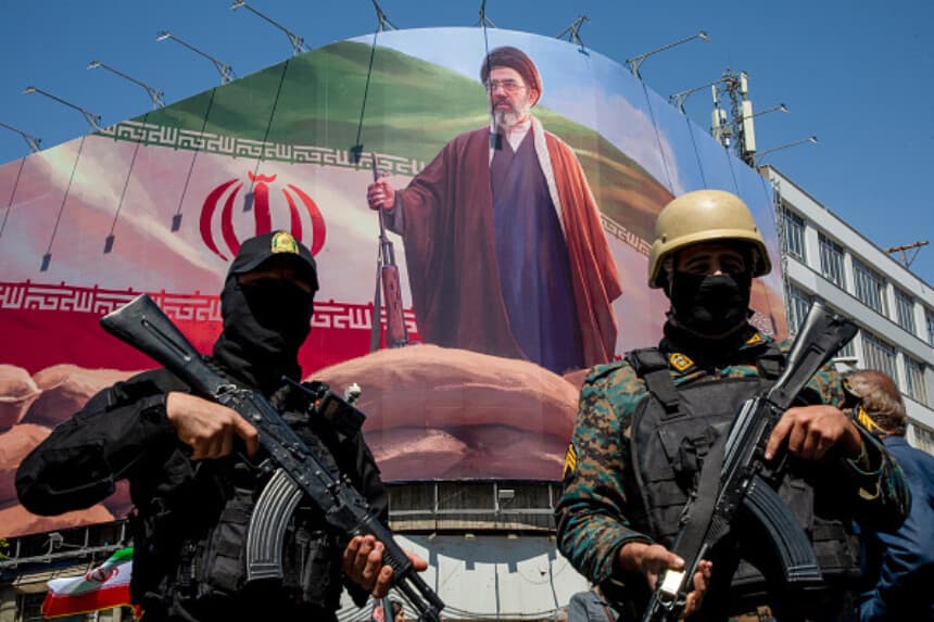 Miembros de las fuerzas de seguridad iraníes montan guardia bajo una pancarta del líder supremo de Irán, Mojtaba Khamenei, durante un acto conmemorativo en Teherán el 9 de abril de 2026, que marcó el 40.º día de la muerte de su padre, el ayatolá Ali Khamenei, en ataques conjuntos entre Estados Unidos e Israel. El 8 de abril, el presidente Donald Trump anunció un alto el fuego de dos semanas entre Estados Unidos e Irán, condicionado a la reanudación del tráfico marítimo en el estrecho de Ormuz. (Majid Saeedi/Getty Images).