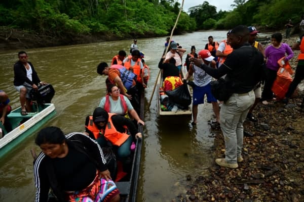 Los migrantes se preparan para desembarcar a su llegada al Centro de Acogida Temporal para Migrantes de Lajas Blancas, en la provincia selvática de Darién, a 250 km al este de la ciudad de Panamá, el 26 de septiembre de 2024. (MARTIN BERNETTI/AFP vía Getty Images)