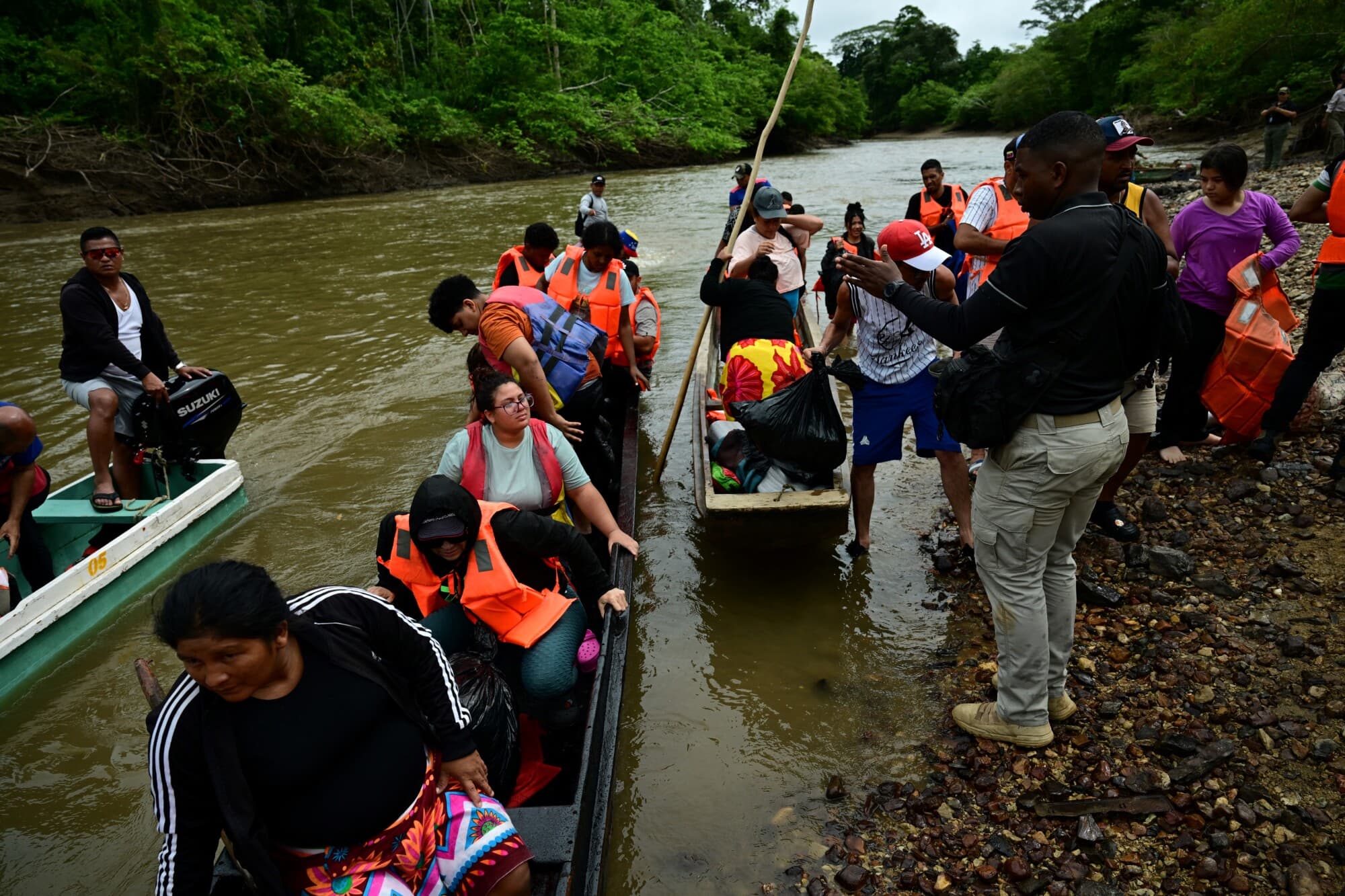 Los migrantes se preparan para desembarcar a su llegada al Centro de Acogida Temporal para Migrantes de Lajas Blancas, en la provincia selvática de Darién, a 250 km al este de la ciudad de Panamá, el 26 de septiembre de 2024. (MARTIN BERNETTI/AFP vía Getty Images)