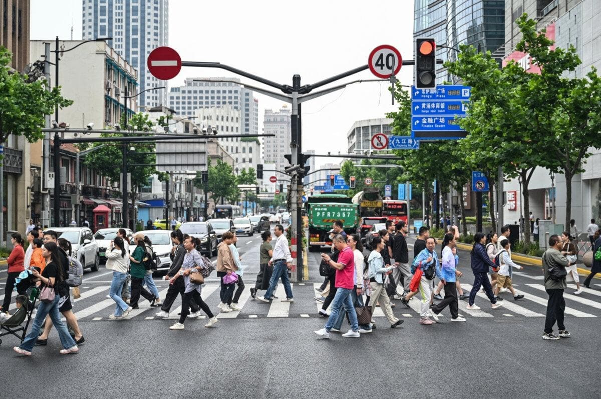 La gente cruza una calle en el distrito de Huangpu, en Shanghái, el 6 de junio de 2024. (Héctor Retamal/AFP vía Getty Images)