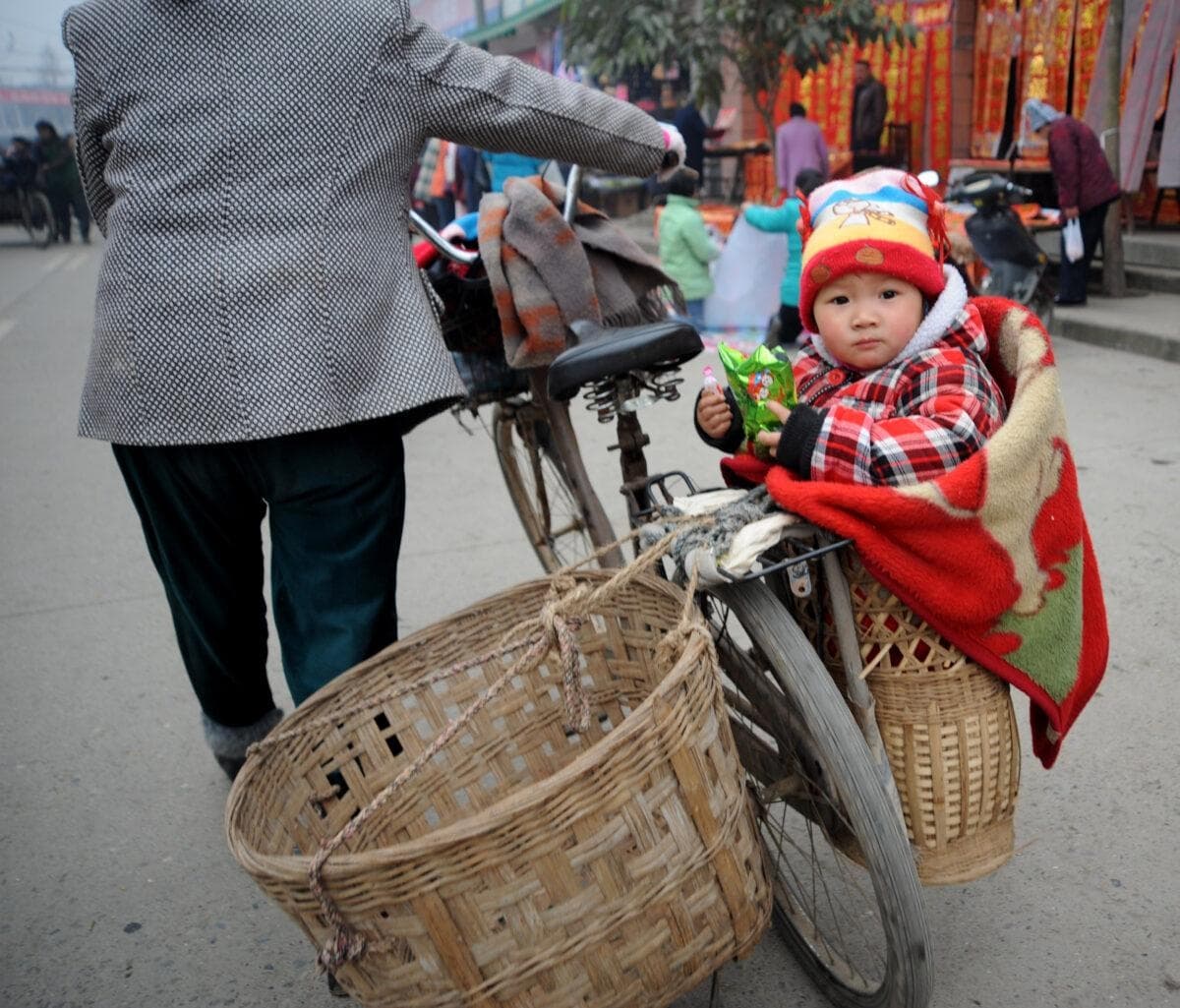 Un bebé sentado en una cesta en el distrito de Qingbaijiang, Chengdu, provincia de Sichuan, China, el 16 de enero de 2009. (China Photos/Getty Images)