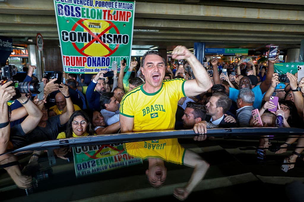 <em>El senador brasileño Flavio Bolsonaro saluda a sus seguidores a su llegada procedente de Estados Unidos al Aeropuerto Internacional de Brasilia, el 28 de mayo de 2026. (Foto de Sergio Lima / AFP vía Getty Images)</em>