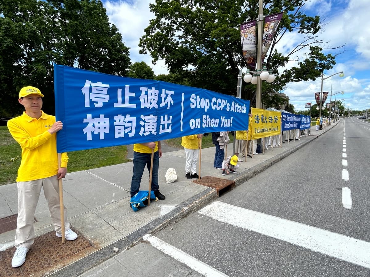 Los practicantes de Falun Gong sostienen pancartas frente al edificio de Asuntos Globales en Ottawa para protestar contra la visita a Canadá del ministro de Asuntos Exteriores chino, Wang Yi, el 28 de mayo de 2026. (The Epoch Times)