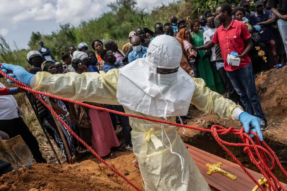 Trabajadores de la Cruz Roja preparan un ataúd con el cuerpo de una víctima de ébola para su entierro en el cementerio de Rwampara, en Rwampara, Congo, el 23 de mayo de 2026. (Foto de Moses Sawasawa/AP).