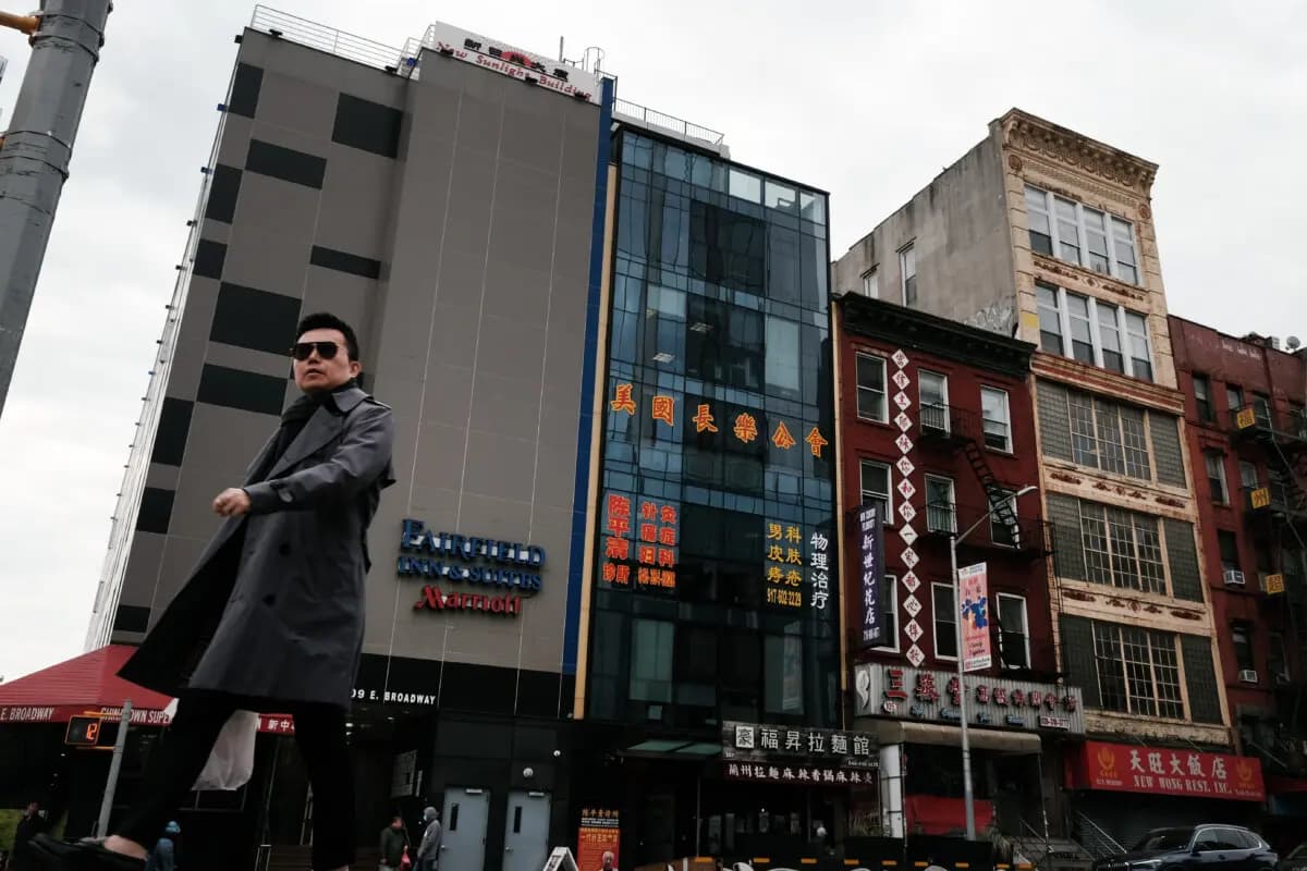 <em>Varias personas pasan junto a un edificio (en el centro) que se sospecha que funciona como comisaría secreta en Chinatown con el fin de reprimir a los disidentes que viven en Estados Unidos en nombre del régimen chino. El edificio se encuentra en el bajo Manhattan, en la ciudad de Nueva York, el 18 de abril de 2023. (Spencer Platt/Getty Images).</em>