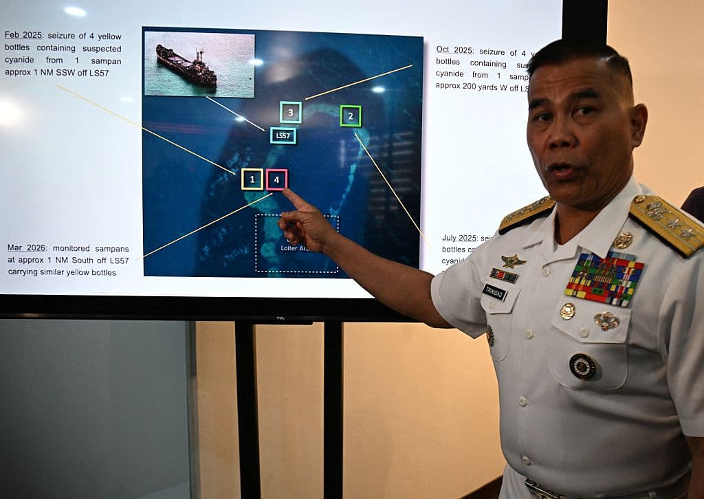 <em>El portavoz de la Armada filipina, el contralmirante Roy Vincent Trinidad, señala una fotografía donde soldados filipinos confiscan botellas amarillas a pescadores chinos que se sospecha contienen cianuro en las aguas del banco de arena Second Thomas, en el disputado mar de China Meridional, durante una conferencia de prensa en Manila el 13 de abril de 2026. Filipinas acusó a pescadores chinos ese mismo día de verter cianuro en las aguas de las islas Spratly, un punto crítico en el disputado mar de China Meridional que ha sido escenario de violentos enfrentamientos con buques chinos. (Foto de Ted ALJIBE / AFP vía Getty Images)</em>
