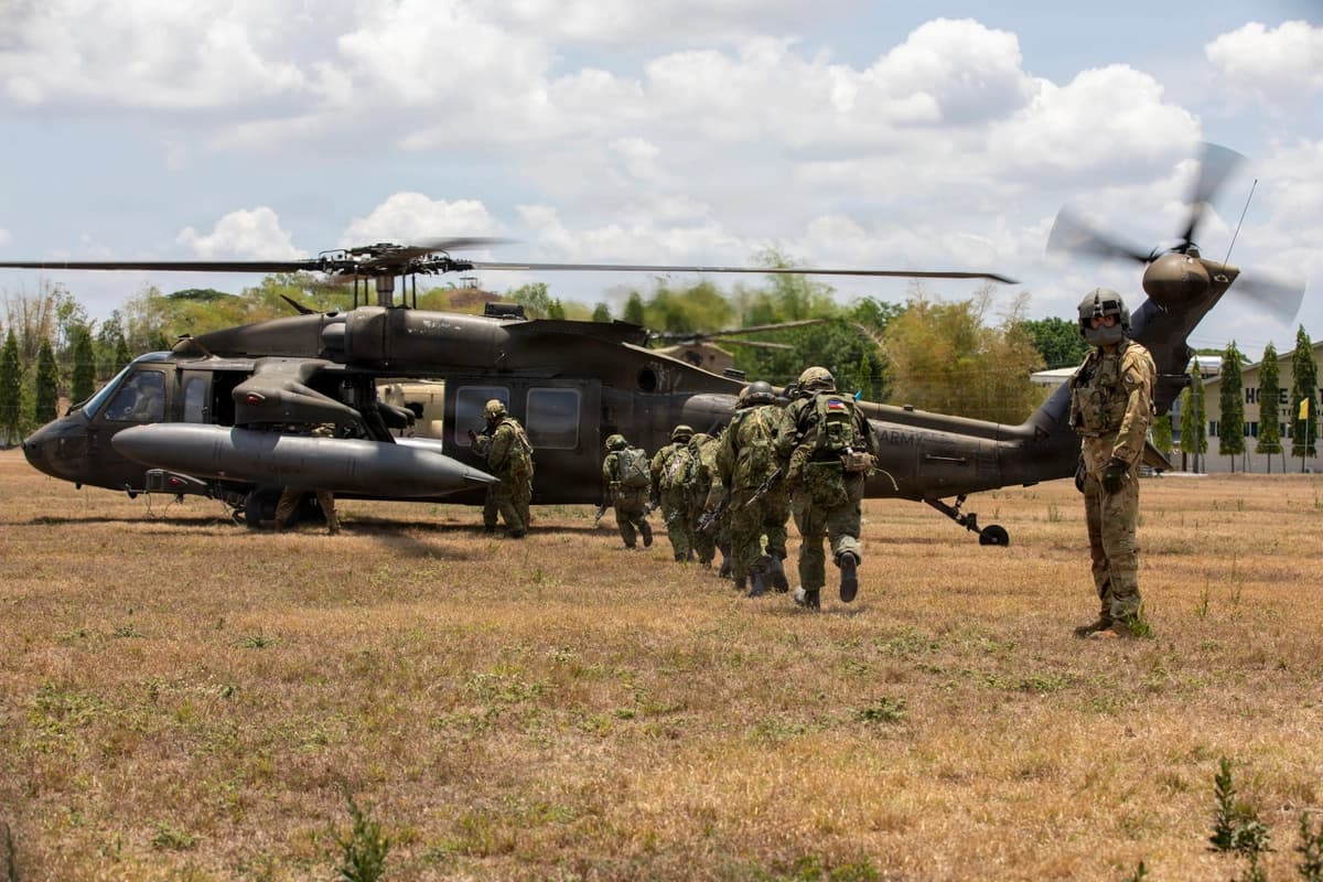El cabo Jonathan Zyk del Ejército de EE. UU. guía a soldados de la Fuerza Terrestre de Autodefensa de Japón hacia un helicóptero UH-60 Black Hawk durante ejercicios multinacionales en la Base Aérea Coronel Ernesto Ravina en Capas, Tarlac, Filipinas, el 17 de mayo de 2026. (Fotografía del Ejército de EE. UU. por el sargento Jameson Harris).
