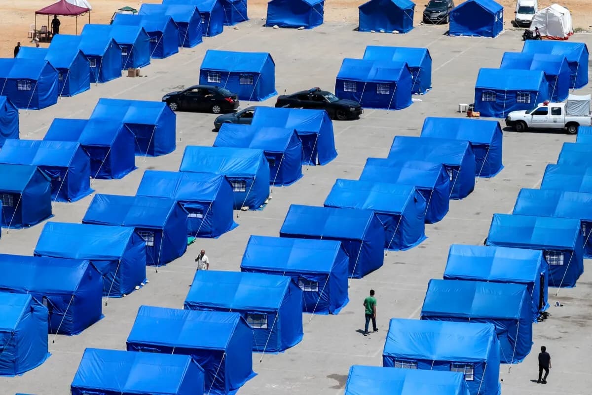 Desplazados libaneses caminan entre tiendas azules instaladas por el Gobierno para las personas que huyeron de sus hogares y pueblos en los suburbios del sur de Beirut y el sur del Líbano, en sustitución de los asentamientos informales de tiendas de campaña en el paseo marítimo de la capital, el 22 de mayo de 2026. (Anwar Amro/AFP vía Getty Images)