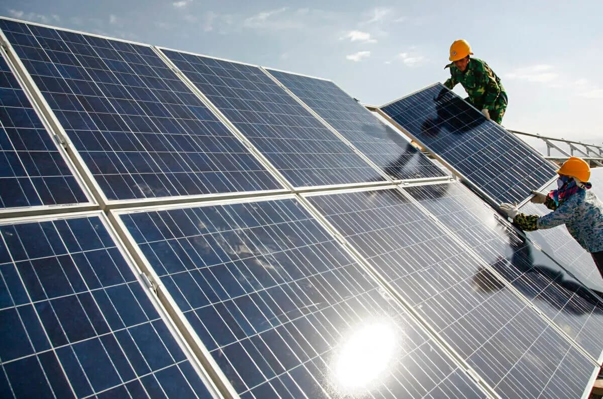 Trabajadores instalan paneles solares en una central fotovoltaica en Hami, en la Región Autónoma Uigur de Xinjiang, al noroeste de China, el 22 de agosto de 2011. (Chinatopix vía AP)