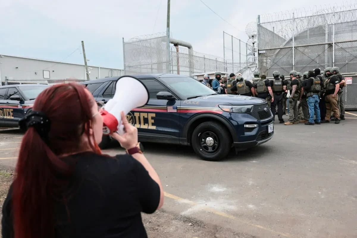 Agentes del Servicio de Inmigración y Control de Aduanas (ICE) montan guardia frente a los manifestantes reunidos frente al Delaney Hall en Newark, Nueva Jersey, el 27 de mayo de 2026. (Michael M. Santiago/Getty Images)