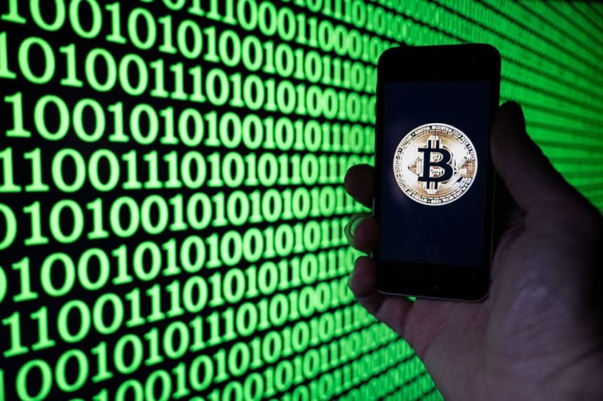 Esta fotografía ilustrativa muestra a un hombre sosteniendo un teléfono en el que se ve el logotipo de Bitcoin, en Mulhouse, el 5 de diciembre de 2025. (SEBASTIEN BOZON / AFP vía Getty Images)