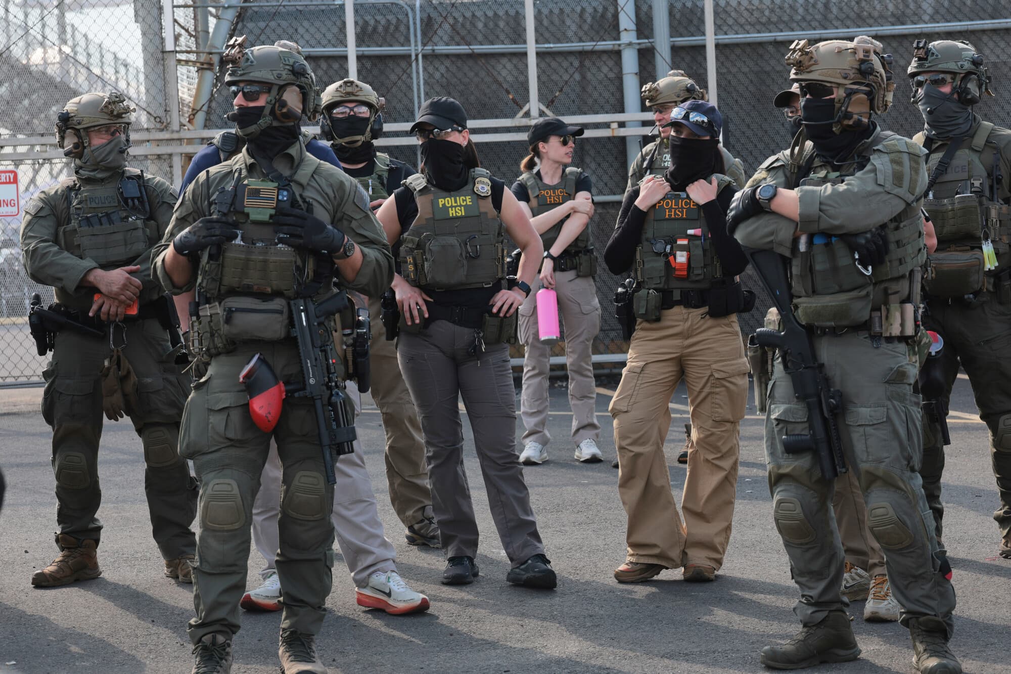 Agentes de Investigaciones de Seguridad Nacional (HSI) montan guardia frente a los manifestantes que se encuentran frente al Delaney Hall, edificio que se utiliza como centro de detención del Servicio de Inmigración y Control de Aduanas, el 29 de mayo de 2026 en Newark, Nueva Jersey. (Michael M. Santiago/Getty Images)