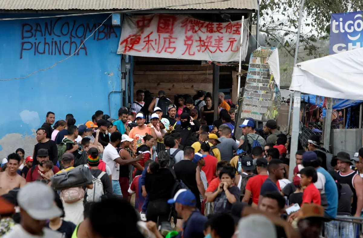 Los migrantes hacen cola para tramitar su inmigración mientras los comerciantes ofrecen servicios tanto en español como en chino en Lajas Blancas, Panamá, el 17 de febrero de 2024. (Bobby Sánchez para The Epoch Times)