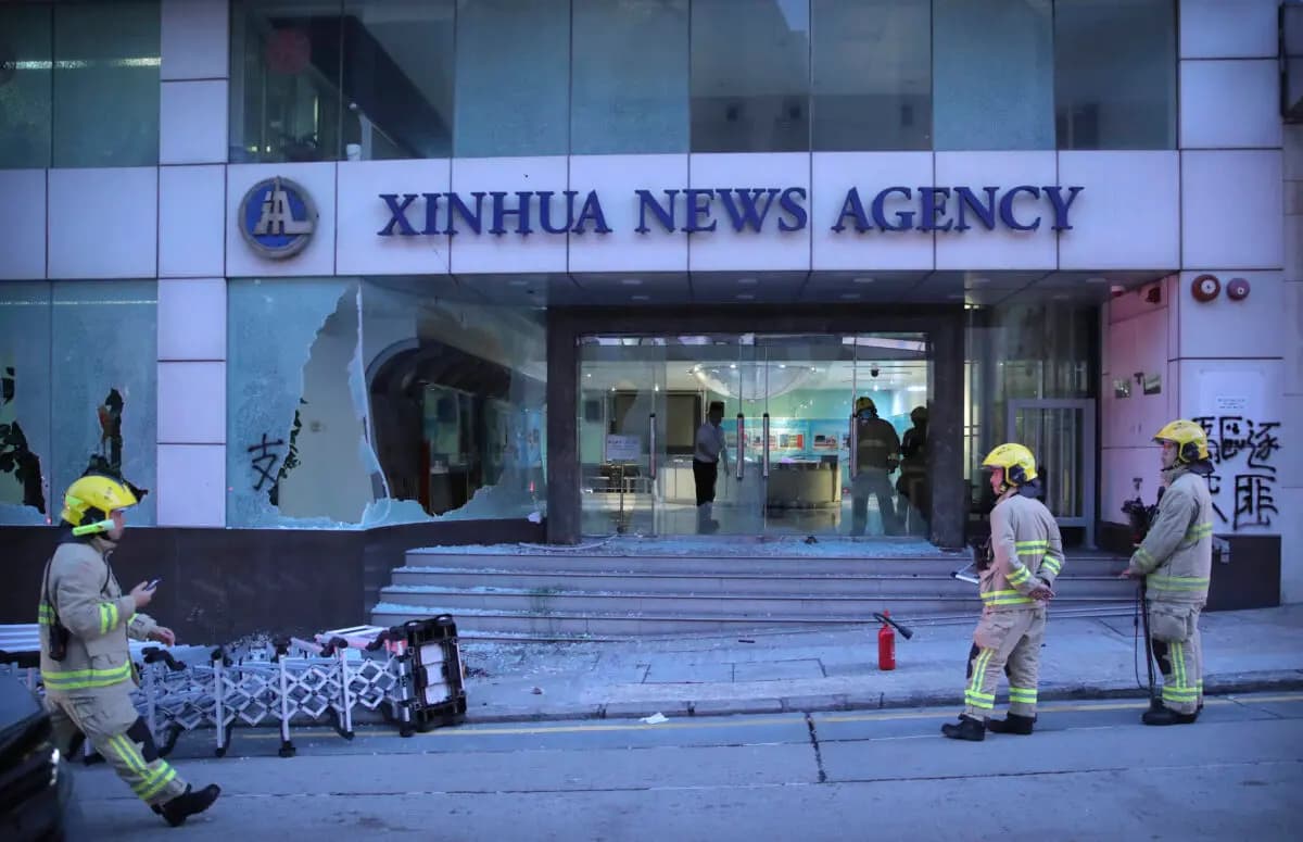 Bomberos frente a las oficinas de la agencia de noticias china Xinhua después de que sus ventanas fueran destrozadas durante las protestas en Hong Kong, el 2 de noviembre de 2019. (Kin Cheung /AP Photo)