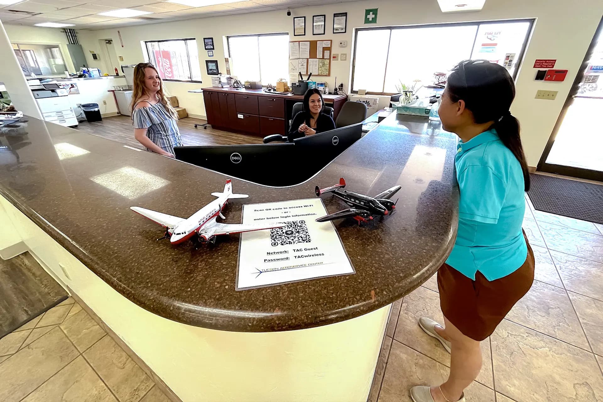 Empleados del Aeropuerto Regional de Marana conversan con la piloto Jessica Cox (derecha) en Marana, Arizona, el 22 de mayo de 2026. Cox afirma que la palabra "no puedo" nunca ha formado parte de su mentalidad. (Allan Stein/The Epoch Times)