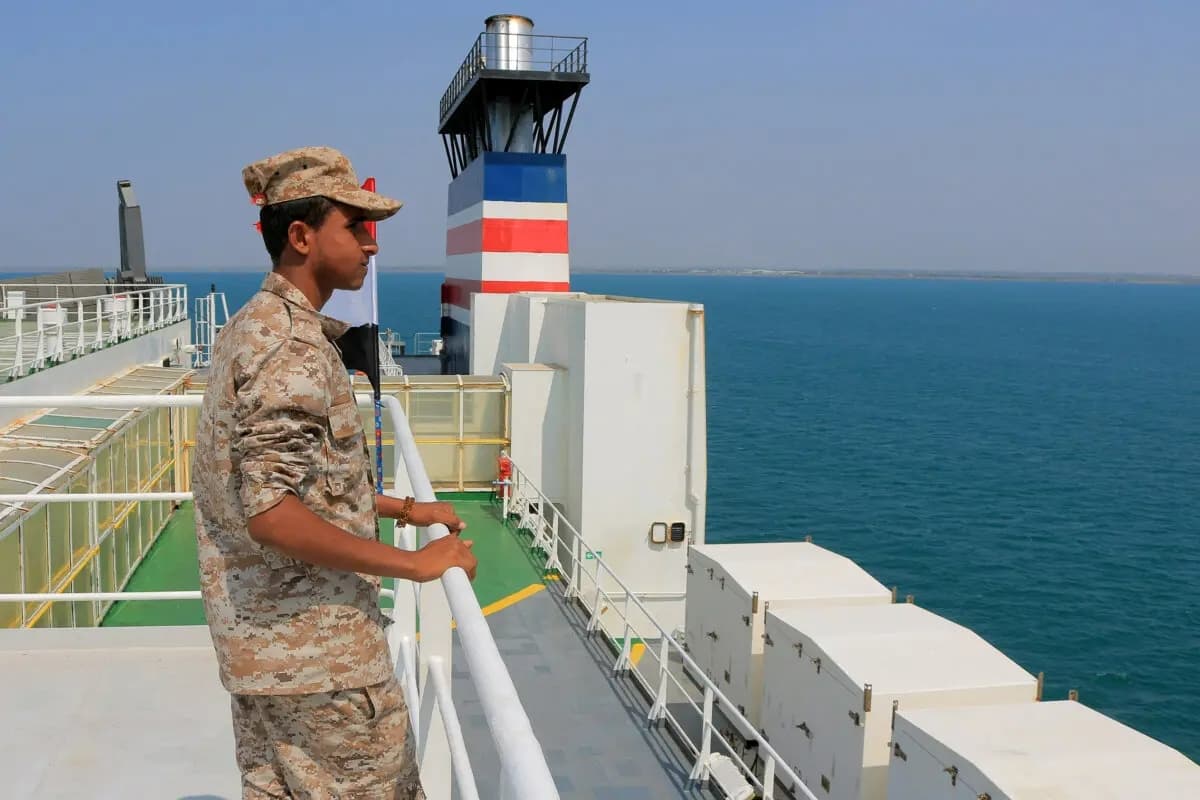 Una fotografía tomada durante una visita organizada por los hutíes de Yemen muestra a un guardia de seguridad a bordo del buque de carga Galaxy Leader, capturado por combatientes hutíes dos días antes, en un puerto del mar Rojo en la provincia yemení de Hodeida, con banderas palestinas y yemeníes izadas en él, el 22 de noviembre de 2023. (AFP vía Getty Images)
