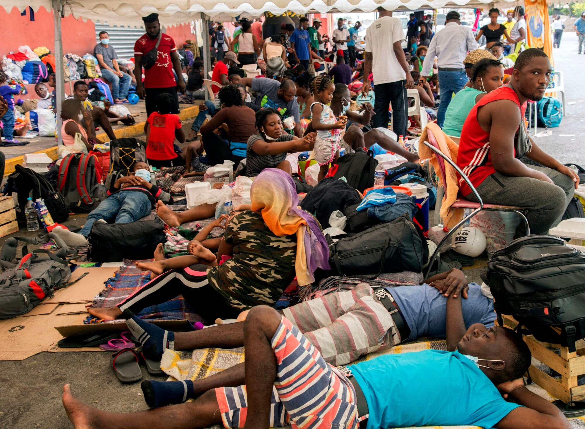Migrantes haitianos descansan afuera de un albergue para migrantes a la espera de la resolución de su caso migratorio, en Monterrey, México, el 26 de septiembre de 2021. (Julio César Aguilar/AFP vía Getty Images)
