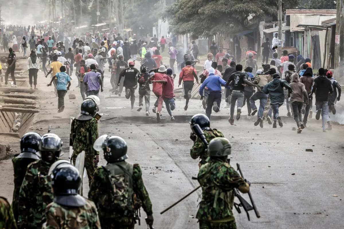 Los manifestantes corren a refugiarse durante los enfrentamientos con agentes de policía de Kenia en una manifestación contra un controvertido centro de cuarentena para el ébola construido por Estados Unidos, cuya puesta en marcha está prevista en la base aérea de Laikipia, en Nanyuki, Nairobi (África), el 9 de junio de 2026. (Luis Tato / AFP vía Getty Images)
