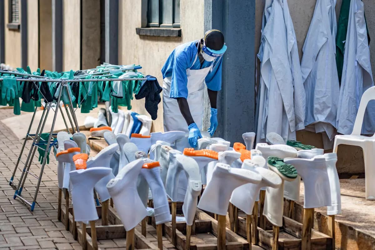 <em>Un trabajador de la salud seca botas de goma y guantes al sol en la unidad de aislamiento del Hospital Nacional de Referencia de Mulago en Kampala, Uganda, el 8 de junio de 2026. (Badru Katumba/AFP vía Getty Images).</em>