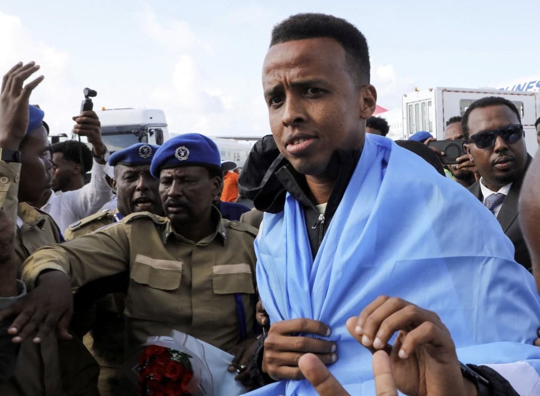 El árbitro somalí Omar Abdulkadir Artan, quien debía arbitrar partidos durante la Copa del Mundo pero a quien se le negó la entrada a Estados Unidos, es recibido a su llegada al Aeropuerto Internacional Aden Abdulle Osman en Mogadiscio, Somalia, el 10 de junio de 2026. (Feisal Omar/Reuters).