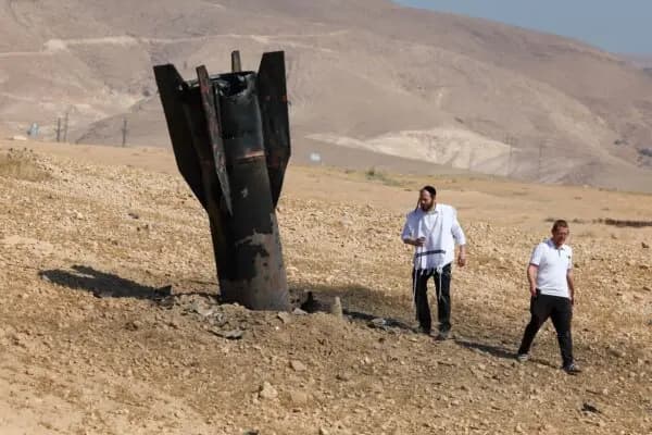 Dos hombres examinan un cohete caído y semienterrado en el suelo, tras los ataques perpetrados por Irán y los rebeldes hutíes respaldados por Irán en las afueras de Jericó, Israel, el 8 de junio de 2026. (Ahmad Gharabli/AFP vía Getty Images).