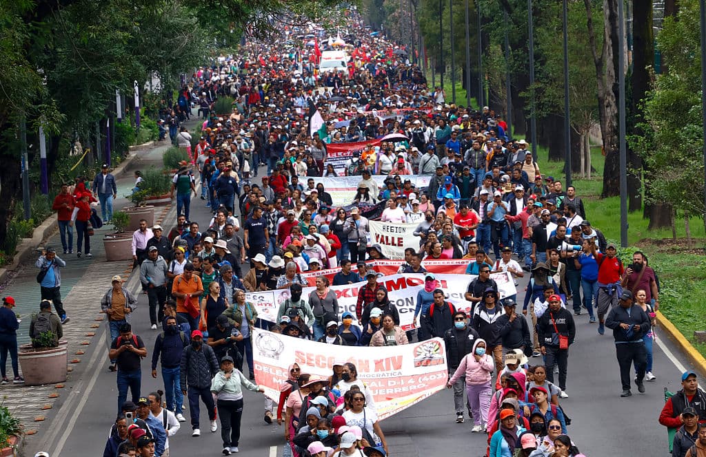<em>Maestros y estudiantes de la escuela Ayotzinapa marchan hacia el Estadio Ciudad de México en la Ciudad de México el 9 de junio de 2026. Miles de maestros bloquearon una avenida que conduce al Estadio Azteca en la Ciudad de México, 48 horas antes de la ceremonia inaugural de la Copa Mundial 2026 en esa sede. (Gerardo Magallón/AFP vía Getty Images)</em>