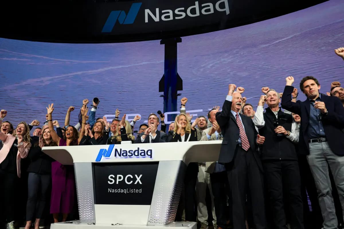 Gwynne Shotwell (en el estrado, en el centro a la derecha), presidenta y directora de operaciones de SpaceX, junto con ejecutivos y empleados de la empresa, toca la campana de apertura en el Nasdaq MarketSite para celebrar el lanzamiento de la oferta pública inicial (OPI) de SpaceX en Nueva York el 12 de junio de 2026. (Timothy A. Clary / AFP vía Getty Images).