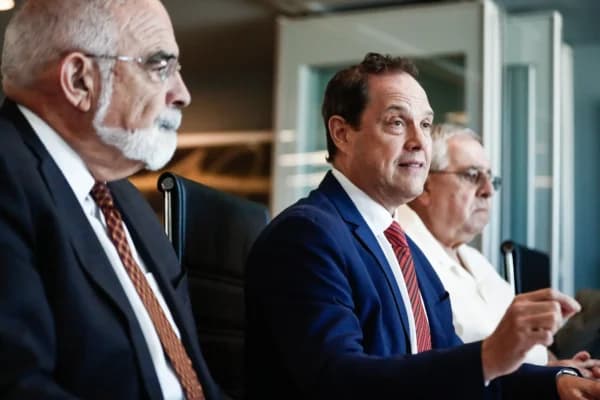 El abogado Andrés Rivero (Centro) habla durante una conferencia de prensa con el acusado José Ramón López Regueiro (Dcha.) en Coral Gables, Florida, el 25 de septiembre de 2019. Rivero presentó una demanda en nombre de Regueiro contra American Airlines y LATAM Airlines Group. La demanda alega que las aerolíneas operan ilegalmente desde el Aeropuerto Internacional José Martí después de que el régimen cubano confiscara el aeropuerto a su familia. (Foto de Brynn Anderson/AP)